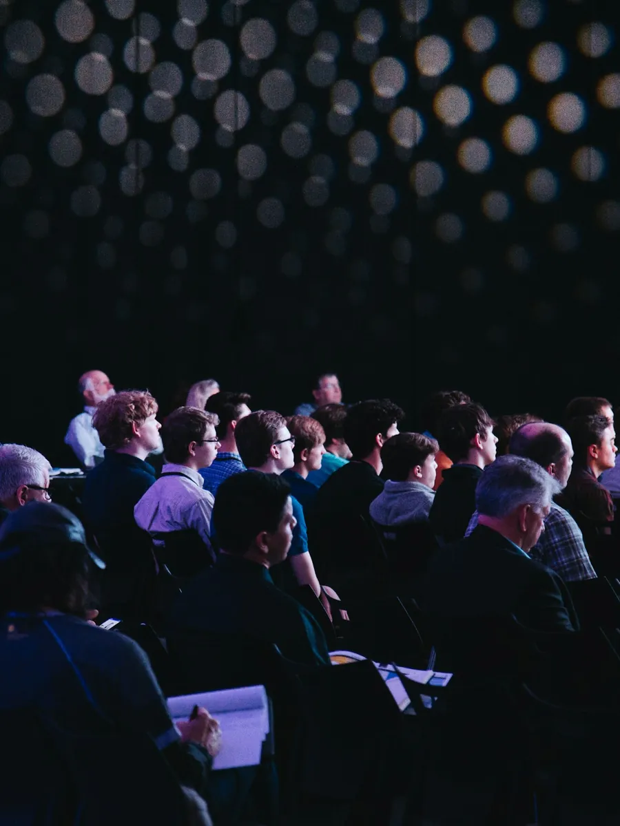 Audience attentive lors d'une plénière de séminaire d'entreprise dans une salle de réunion lumineuse à Lisbonne