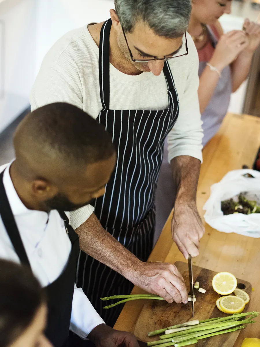 Atelier culinaire collaboratif de team building autour d'un plan de travail garni de produits frais portugais